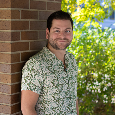 Adam Kibiloski smiles at the camera. 