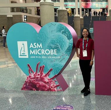 Aathmaja Rangarajan stands next to the ASM Microbe sign in Los Angeles, CA. 