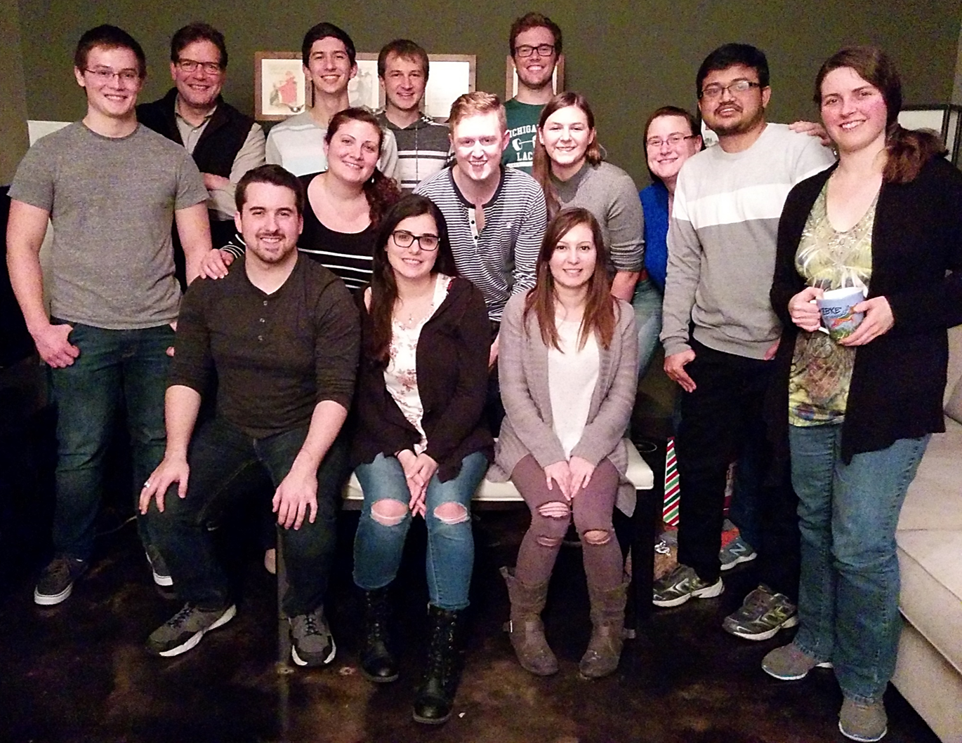 A group of people smile at the camera. They are in a family room.
