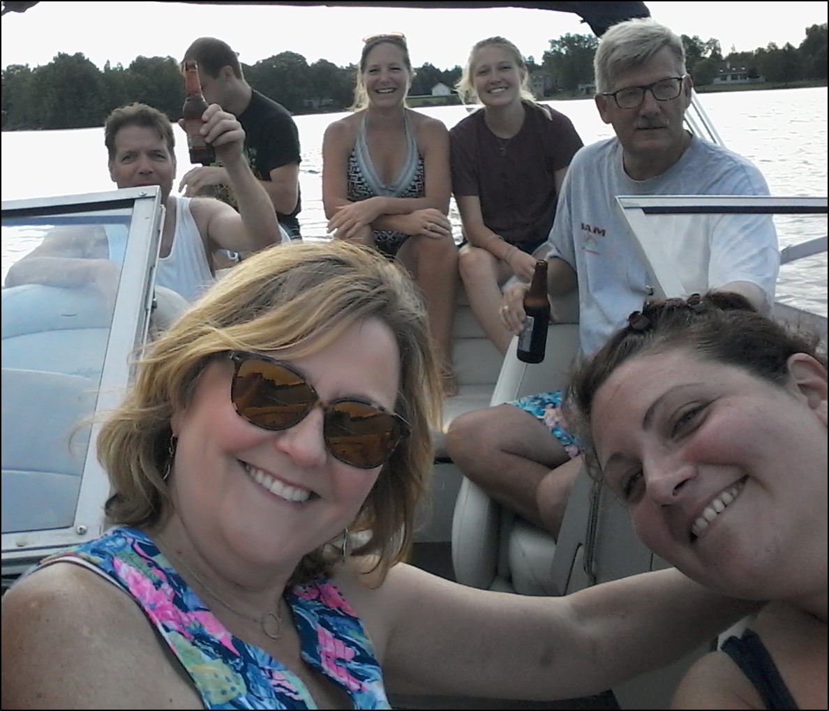 A group of people smile at the camera. They are on a boat.