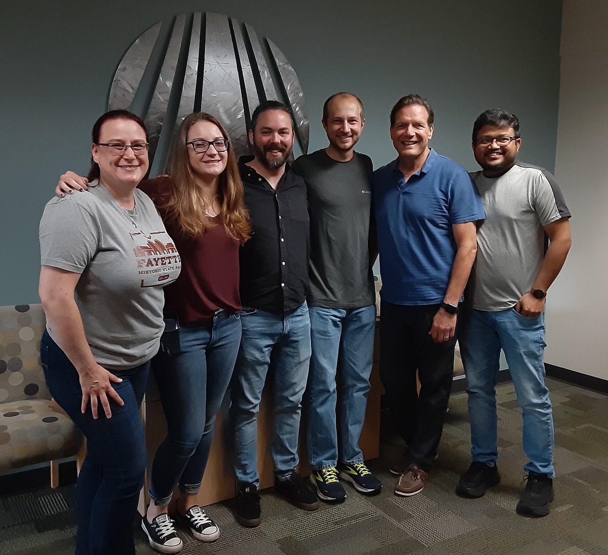 A group of people stand together in the MGI main office.